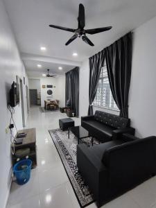 a living room with black furniture and a ceiling fan at Homestay Temerloh Near Hospital 4Bedroom 3Air-cond Free Wi-Fi Netflix in Temerloh