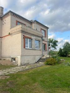 une grande maison en briques avec un escalier dans une cour dans l'établissement Pušų Sodas, à Birštonas 2 autres photos