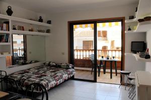 a bedroom with a bed and a table and a balcony at House El Cardon by Holiday World in Playa de las Americas