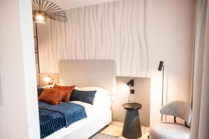 een slaapkamer met een wit bed en een stoel bij Baltic Waves Resort A323 in Międzyzdroje +15 foto's