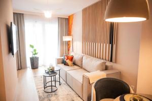 een woonkamer met een bank en een tafel bij Baltic Waves Resort A323 in Międzyzdroje