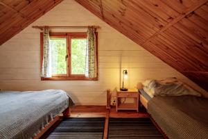 una camera mansardata con due letti e una finestra di Domki Irka nad morzem a Łeba