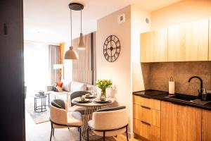 een keuken en woonkamer met een tafel en stoelen bij Baltic Waves Resort A323 in Międzyzdroje