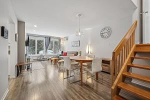 a dining room and living room with a table and chairs at Little Sunshine, Nature retreat, 10min of mountain in Mont-Tremblant