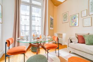 パリにあるCharme et standing - 2 chambres proches Trocadéroのテーブルとソファのあるリビングルーム