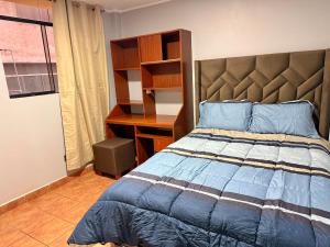 een slaapkamer met een bed en een bureau bij Jaichi KIREI in Cajamarca