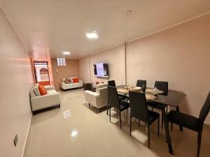 een woonkamer met een tafel, stoelen en een bank bij Jaichi KIREI in Cajamarca