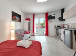 a kitchen and living room with a red bed at Fantastico 1 - Grossem Balkon - Gratis Parkplatz - Klimaanlage - Zentrumsnähe und Meernähe in Puerto de la Cruz