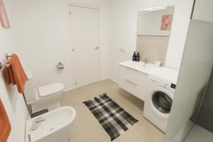 a white bathroom with a washing machine and a sink at Fantastico 1 - Grossem Balkon - Gratis Parkplatz - Klimaanlage - Zentrumsnähe und Meernähe in Puerto de la Cruz