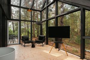 a screened in porch with a flat screen tv at Modernes Tiny House im Spreewald in Münchehofe