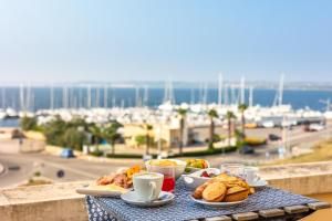 ガリポリにあるB&B Palazzo Vergineの港の景色を望むバルコニーに朝食の食べ物が置かれたテーブル +15枚の写真