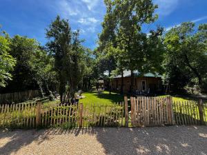 a wooden fence in front of a yard at Country Cottage & Spa in Labalme