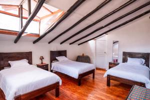 due letti in una stanza con pavimenti in legno di Piedra Wasi Ecolodge Urubamba a Urubamba Altre 32 foto
