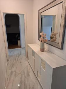 une salle de bain avec un miroir et un vase sur un comptoir dans l'établissement Apartman Lapad, à Split 19 autres photos