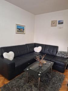 un canapé en cuir noir dans un salon avec une table dans l'établissement Apartman Lapad, à Split