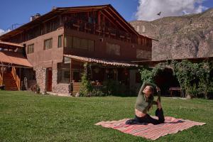 a man sitting on a blanket on the grass at Piedra Wasi Ecolodge Urubamba in Urubamba +91 photos