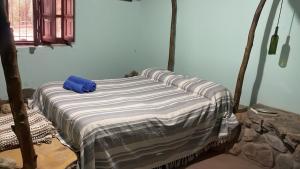 a bed in a room with a blue pillow on it at cabaña bodeguita de adobe in Copacabana
