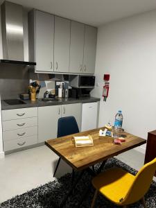 eine Küche mit einem Holztisch und gelben Stühlen in der Unterkunft Arrenquinha Guesthouse # Margarida in São Vicente Ferreira