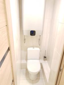 a small bathroom with a white toilet with a tank at Ezerkrasts Kempes 28 in Liepāja +24 photos