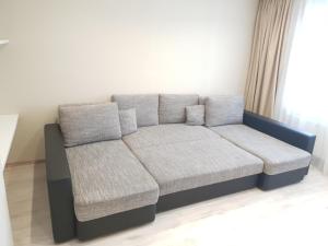 a couch with two pillows in a living room at Ezerkrasts Kempes 28 in Liepāja