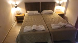 Una habitación de hotel con dos camas con toallas. en Dionysus House Lasithi Plateau, en Magoulás
