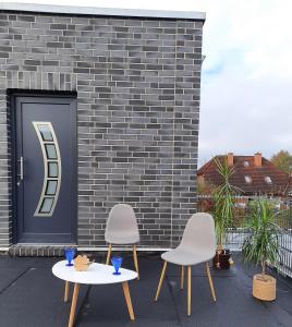 two chairs and a table in front of a building at Ferienwohnung Flora Friesoythe in Friesoythe