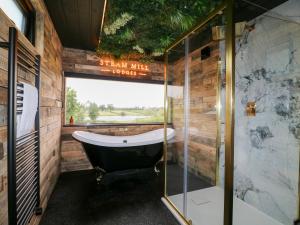 a bathroom with a tub and a glass shower at Hazel in Swadlincote +25 photos
