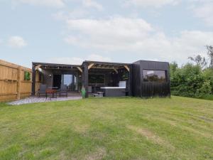 a black house with a green yard at Hazel in Swadlincote