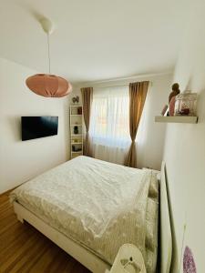 Un dormitorio blanco con una cama y una ventana. en Cozy Apartament 3 min to subway 24h7 check in, en Popeşti-Leordeni 6 fotos más