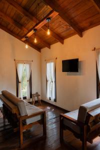 a living room with wooden ceilings and a flat screen tv at Cotan Ecolodge in La Esperanza