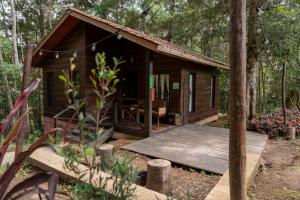 a small wooden cabin with a deck in the woods at Cotan Ecolodge in La Esperanza
