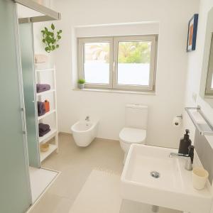 a white bathroom with a toilet and a sink at Fantastico 2 - Grossem Balkon - Gratis Parkplatz - Klimaanlage - Zentrumsnähe und Meernähe in Puerto de la Cruz