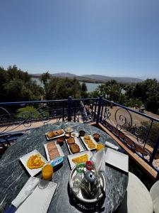 a table with food on top of a balcony at Dar NFis Suites et chambres de luxe dans un havre de paix vue paradisiaque au bord du lac in Lalla Takerkoust