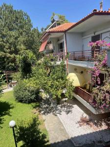 a house with a balcony with flowers on it at Coastal Oasis in Polykhrono