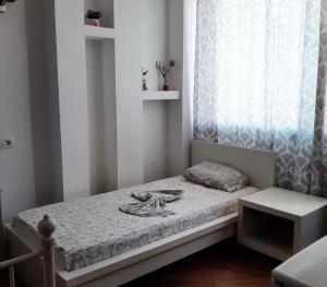 a small bedroom with a bed and a window at Apartmani Monić in Ulcinj