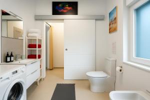 a white bathroom with a washing machine and a sink at Fantastico 3 - Grosser Terrasse - Gratis Parkplatz - Klimaanlage - Zentrumsnähe und Meernähe in Puerto de la Cruz