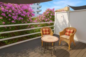 two chairs and a table on a balcony with pink flowers at Fantastico 3 - Grosser Terrasse - Gratis Parkplatz - Klimaanlage - Zentrumsnähe und Meernähe in Puerto de la Cruz +17 photos