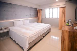 1 dormitorio con 1 cama blanca grande en una habitación en KIWI-Taichung Station Branch 1 en Taichung