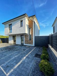 a house with a driveway in front of it at Emerald Home in Suceava