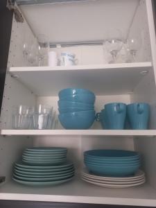 a cabinet filled with plates and bowls and glasses at fuerte blue in Costa Calma