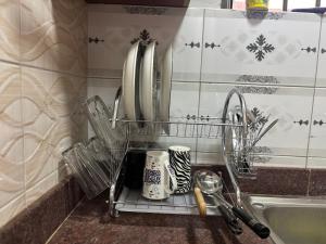 a kitchen counter with utensils in a drying rack at Bukoto Kampala Kickoff Ntinda Luxury apartment in Kampala