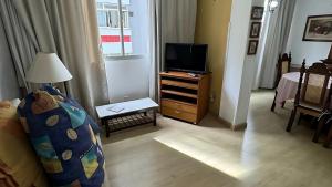 a living room with a bed and a television at Apto Almeida e Moraes charmoso passos da praia de BC in Balneário Camboriú