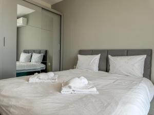 a large white bed with two towels on it at 1BR Apartment with Panoramic View Balcony and Designated Parking Space in Plovdiv