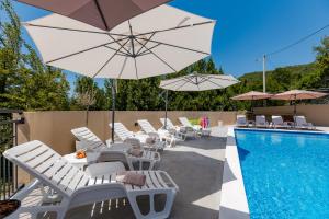 a group of chairs and umbrellas next to a swimming pool at House with Pool - Ratisevina in Herceg-Novi