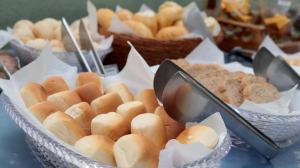 a table topped with baskets of buns and pastries at Valentim Palace Hotel in Valentim Gentil