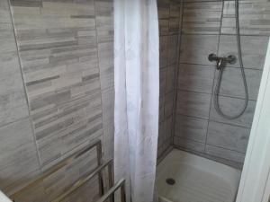 a bathroom with a shower with a shower curtain at Bel appartement climatisé avec balcon 200m de la Plage in Narbonne-Plage