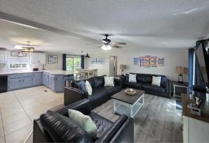 a living room with a black couch and a kitchen at Island Club #95 in Put-in-Bay