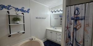 a bathroom with a sink and a shower curtain at Island Club #95 in Put-in-Bay +35 photos