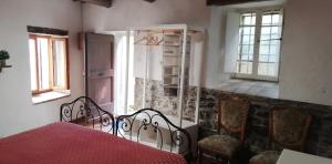 a bedroom with a bed and two chairs and a window at IL BORGHETTO Room&Breakfast in Rocca San Casciano