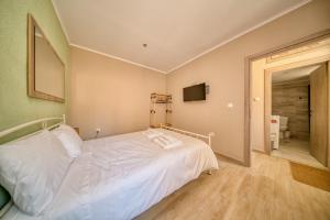 a bedroom with a white bed and a bathroom at Pepita home in Chios